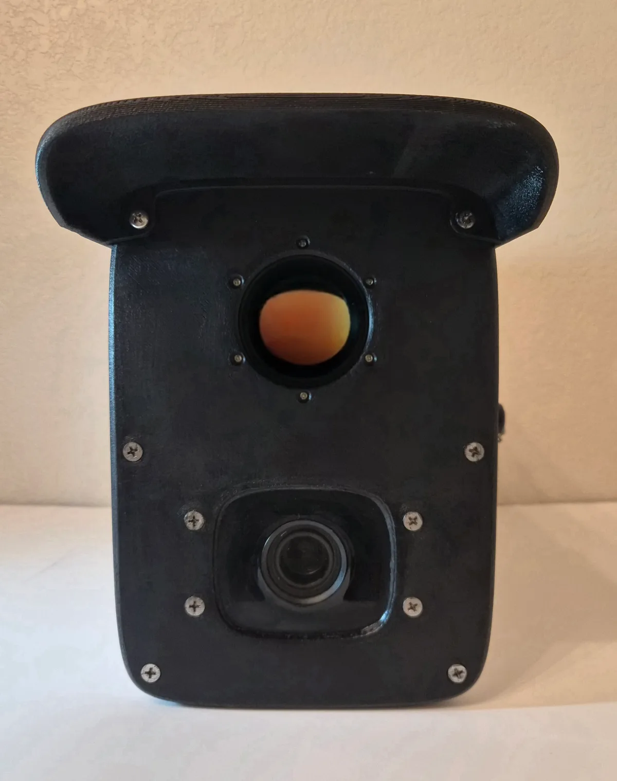 Front view of the CleanConnect Alta unit: the methane OGI camera lens above the optical camera lens, both behind a protective weather hood.